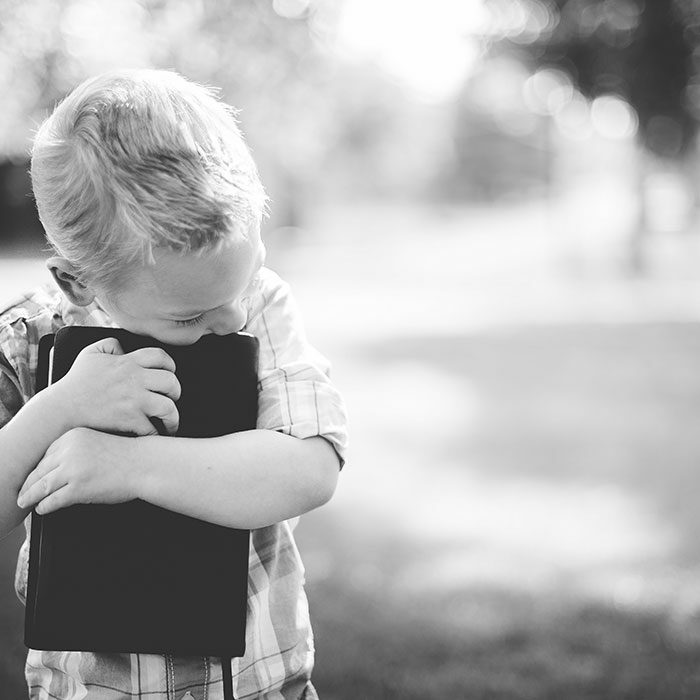 Child hugging bible
